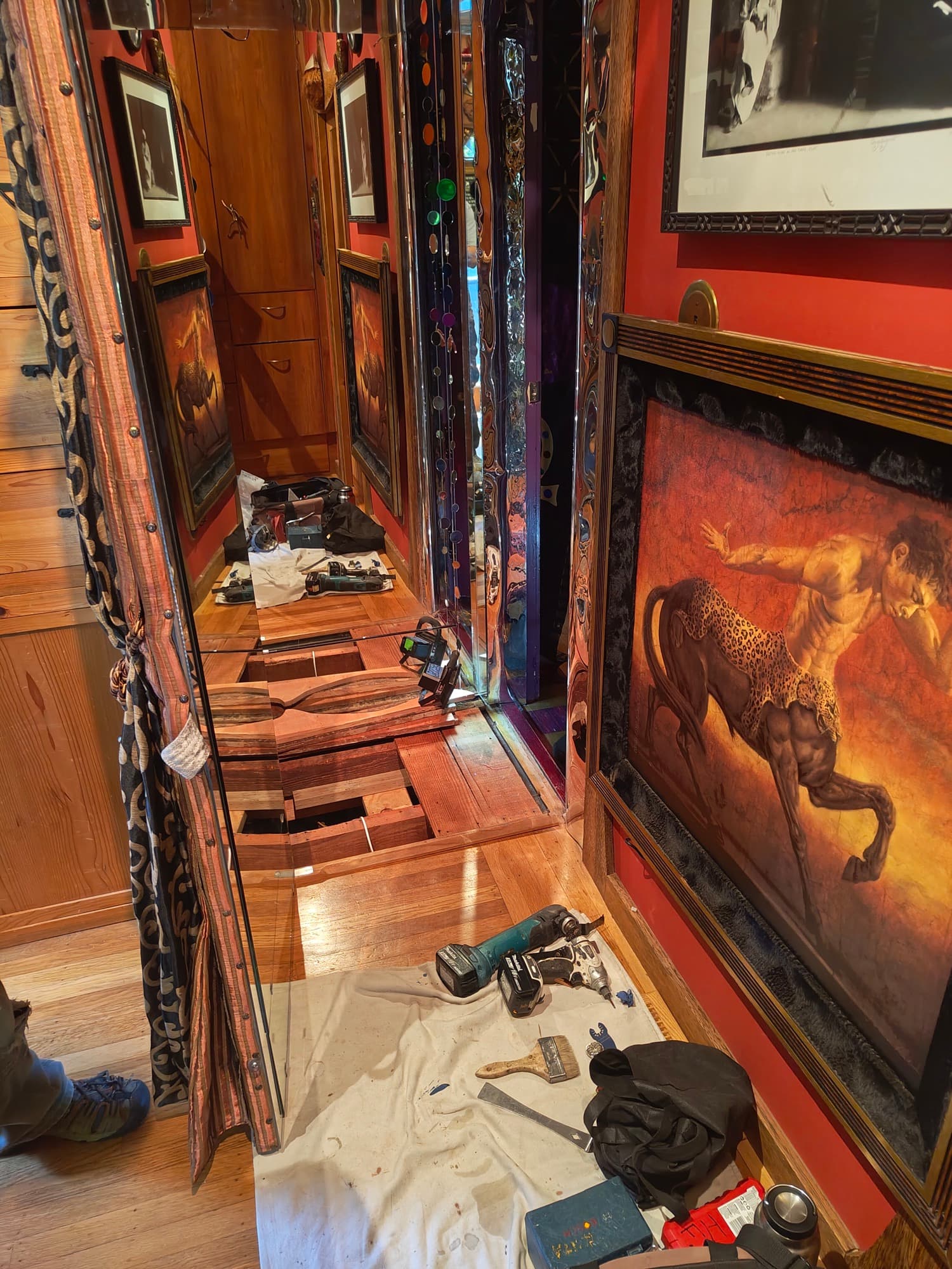 Floorboards cut open along the mirrored corridor
